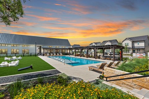 a swimming pool with lounge chairs in front of a building